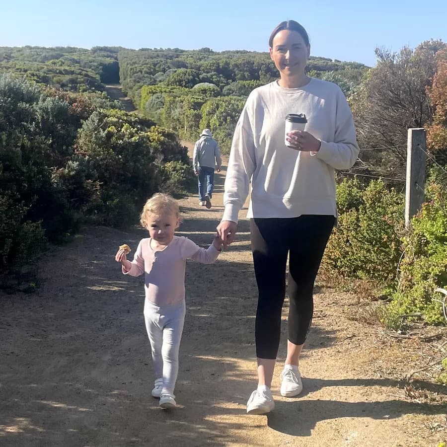 Laurinda W walking a coastal trail hand in hand with her toddler