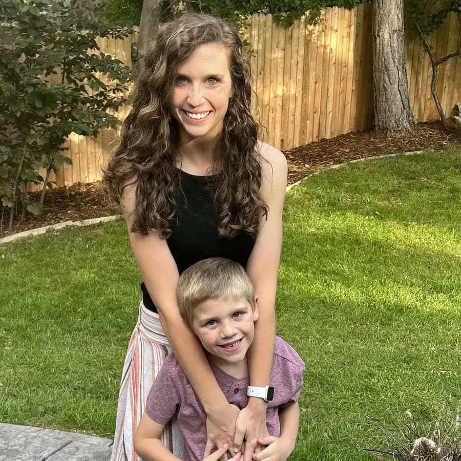 Taylor M in her back garden with her arms around one of her sons